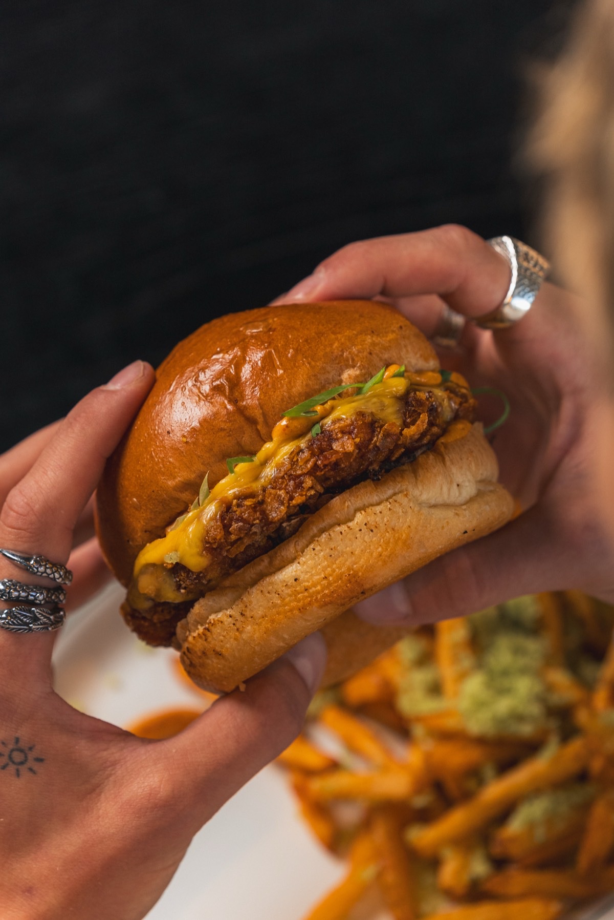 Burger holdt i hendene ved bordet